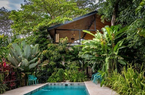 Turquoise pool and open-air wooden pavilion nestled in the Costa Rican jungle at Villa Wanderlust